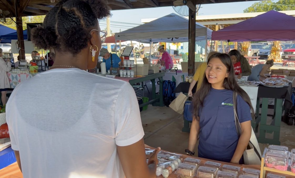 Farm & Agribusiness Management Extension Agent Roshell Rosales Aguilar visits with the Chaidez family during the Athens Farmers Market.